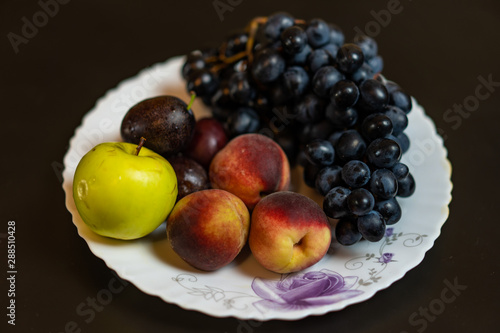 Fototapeta Naklejka Na Ścianę i Meble -  Fruit on a plate grapes peach plum apple