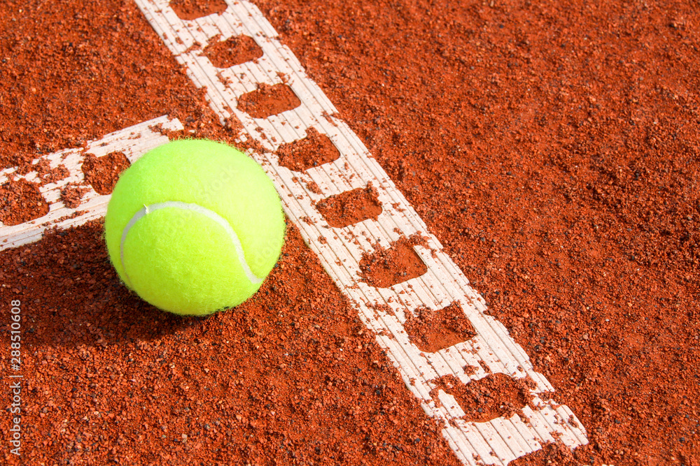 One tennis ball on tennis court with a line