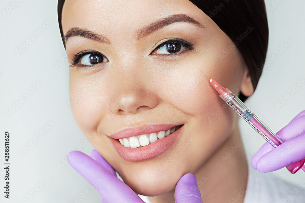 Beautiful Asian woman gets beauty injections. Close-up injection of anti-aging and wrinkle perfect female face Beautiful Asian woman gets beauty injections. Close-up injection of anti-aging and wrinkle perfect female face