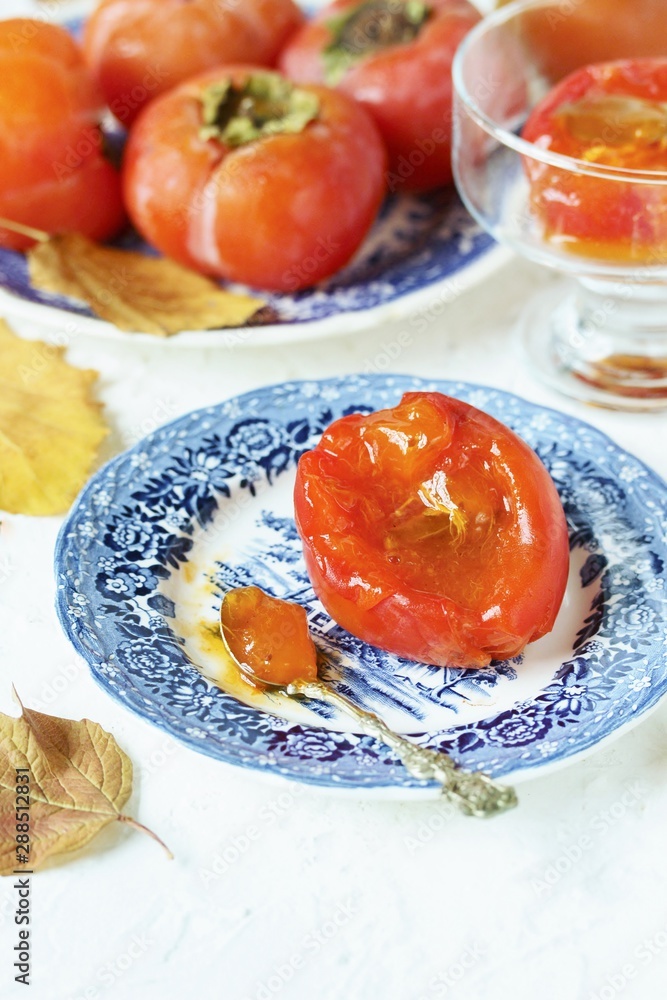 ripe juicy persimmons on a light background. You can eat with spoons like jelly. autumn still life flat. autumn leaves. ripe juicy persimmons on a light background. You can eat with spoons like jelly. autumn still life flat. autumn leaves.