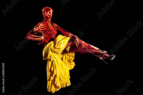 sensual woman dressed in a skeleton costume floating in the air wearing a yellow skirt