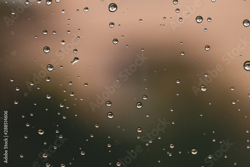 Raindrops on window glass close up. water drops abstract macro background