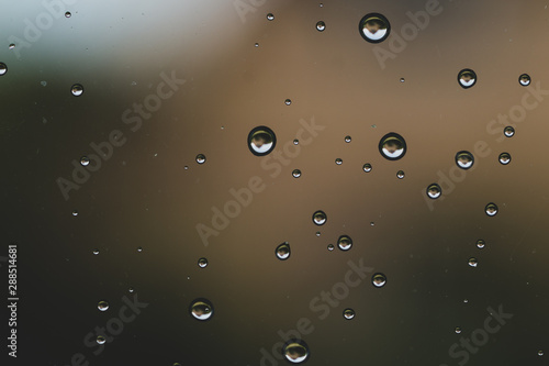 Raindrops on window glass close up. water drops abstract macro background