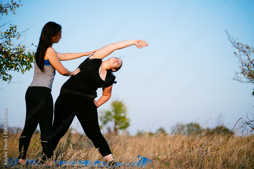 Overweight woman training with trainer support
