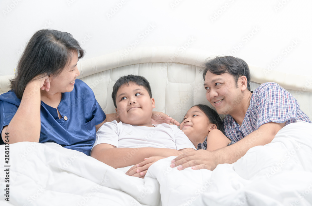 Asian Happy young family lying in bed together Asian Happy young family lying in bed together