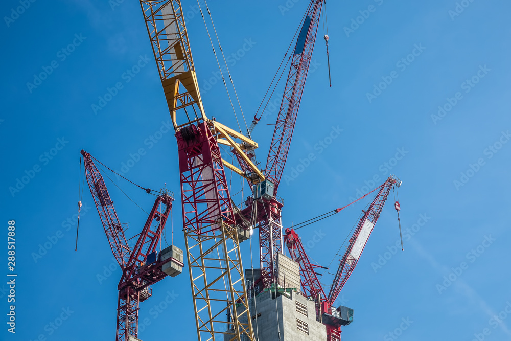 Multiple tower cranes above a concrete structure. Multiple tower cranes above a concrete structure.