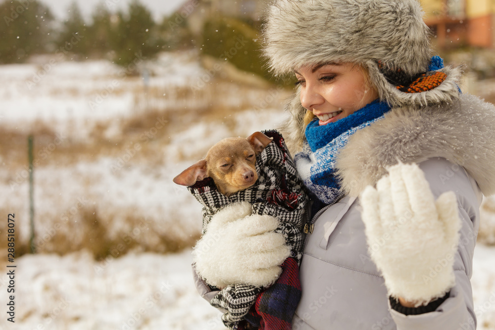 Woman hug warming her little dog in winter Woman hug warming her little dog in winter