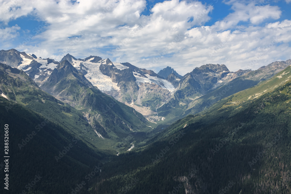 Panorama of mountains scene with dramatic blue sky in national park of Dombay