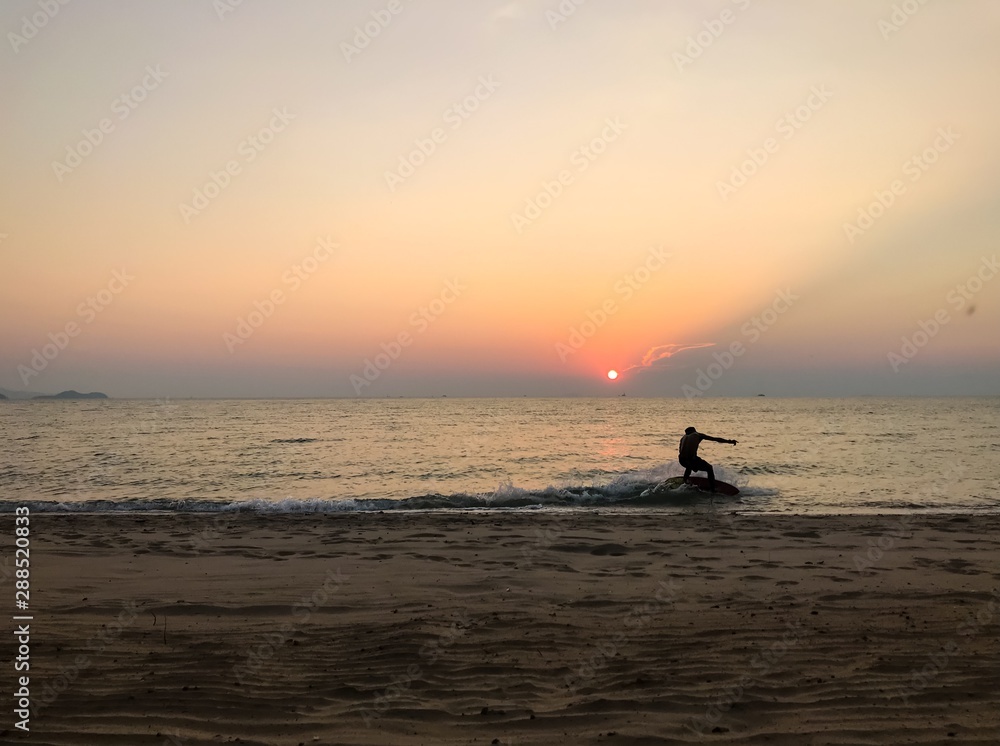 A man is surfing when sunset