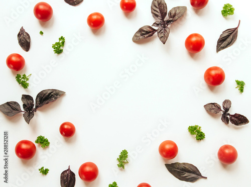 frame of cherry tomato, purple basil leaves and parsley on a white isolated background with space for text