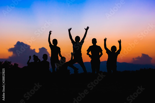 Silhouette picture of happy jumping kids. For concept like win or success and teamwork.