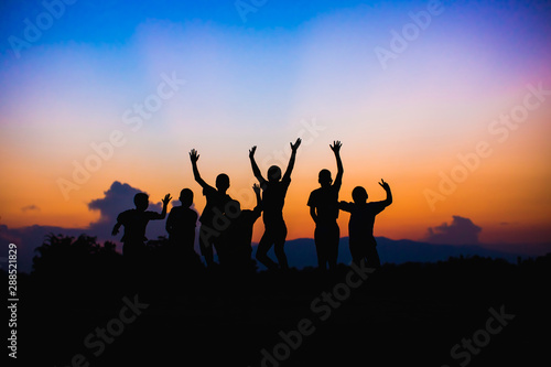 Silhouette picture of happy jumping kids. For concept like win or success and teamwork.