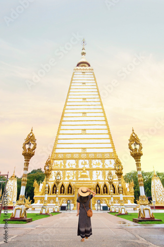 Woman tourist is traveling and sightseeing at Maha Pho Chedi at Wat Phra That Nong Bua, Ubon Ratchathani, Thailand. photo