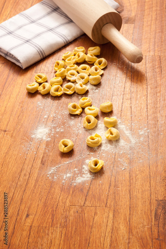 raw, uncooked Italian filled pasta tortellini ravioli on the table in rustic way