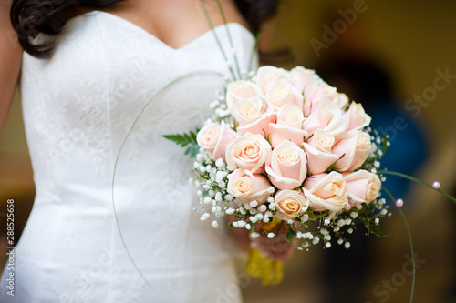 bride holds her bouquet in her arms  close-up  no face