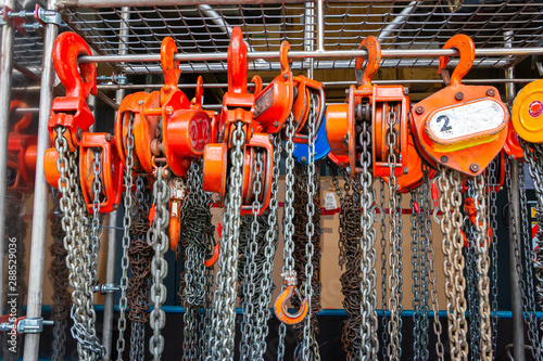 Multiple chain hoists hanging in a rack ready for use in a industrial environment, picture taken in the Netherlands photo