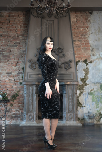 Gothic slim caucasian girl in black tight dress posing in her room