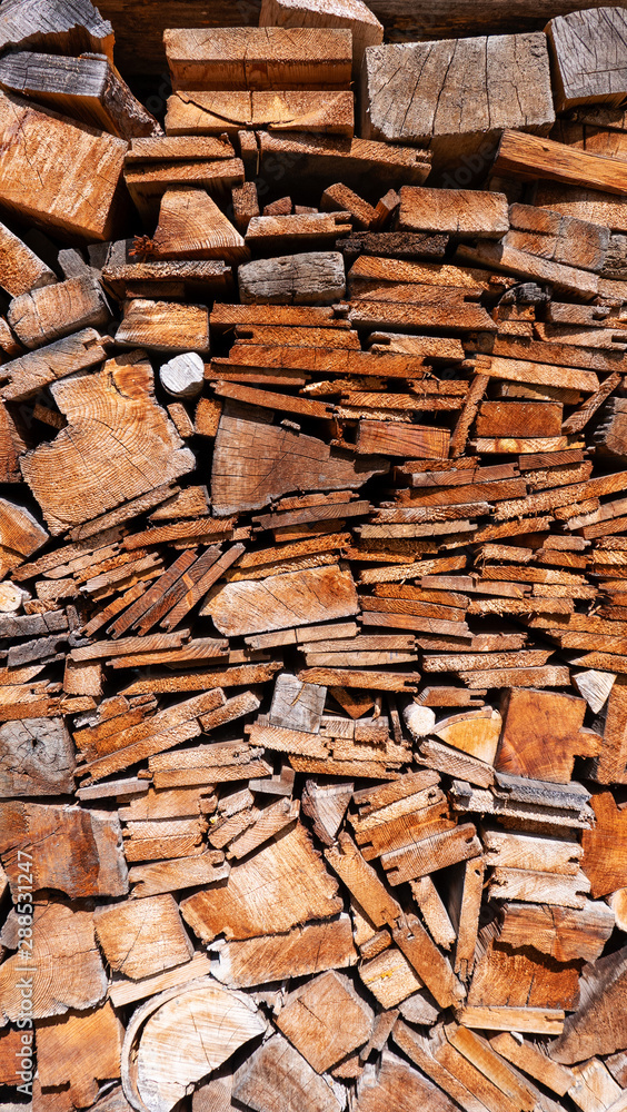 Large pile of sawn wood in different sizes and shapes in vertical format Large pile of sawn wood in different sizes and shapes in vertical format