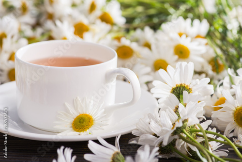 Fototapeta Naklejka Na Ścianę i Meble -  Cup of chamomile herbal tea with flowers
