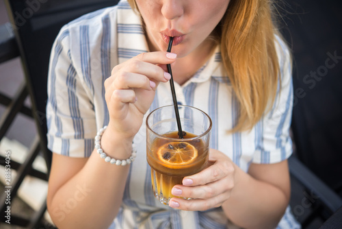 Woman holding a cold summer cocktail with coffee beans