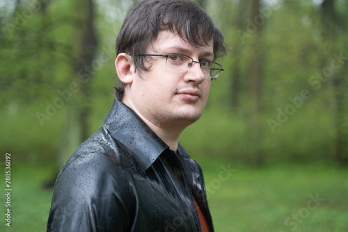 sexy plus size nerd man in latex shirt walking outdoor on the street alone