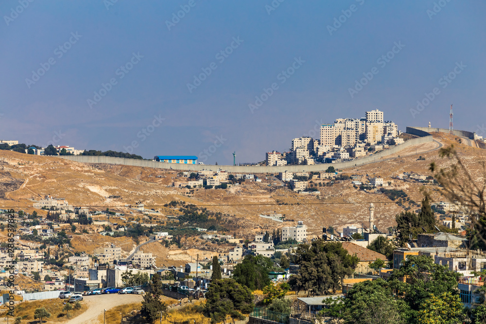 Small village and the Israeli West Bank barrier or wall - separation barrier on the West Bank in Israel. View from Montefiore Windmill