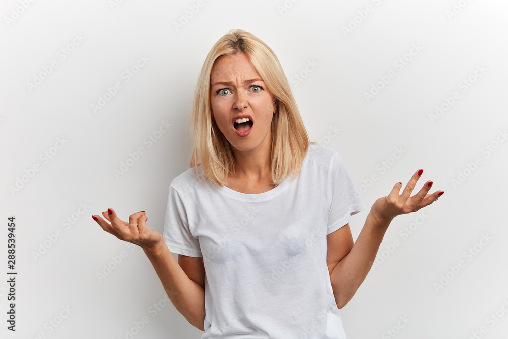 agressive girl having argument with a friend, close up portrait, isolated white background, studio shot agressive girl having argument with a friend, close up portrait, isolated white background, studio shot