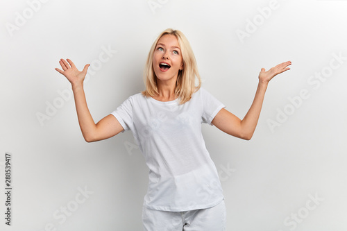 Happy cheerful woman with raised arms looking up , being happy to achieve her goal, celebrating success isolated on white background, facial expression