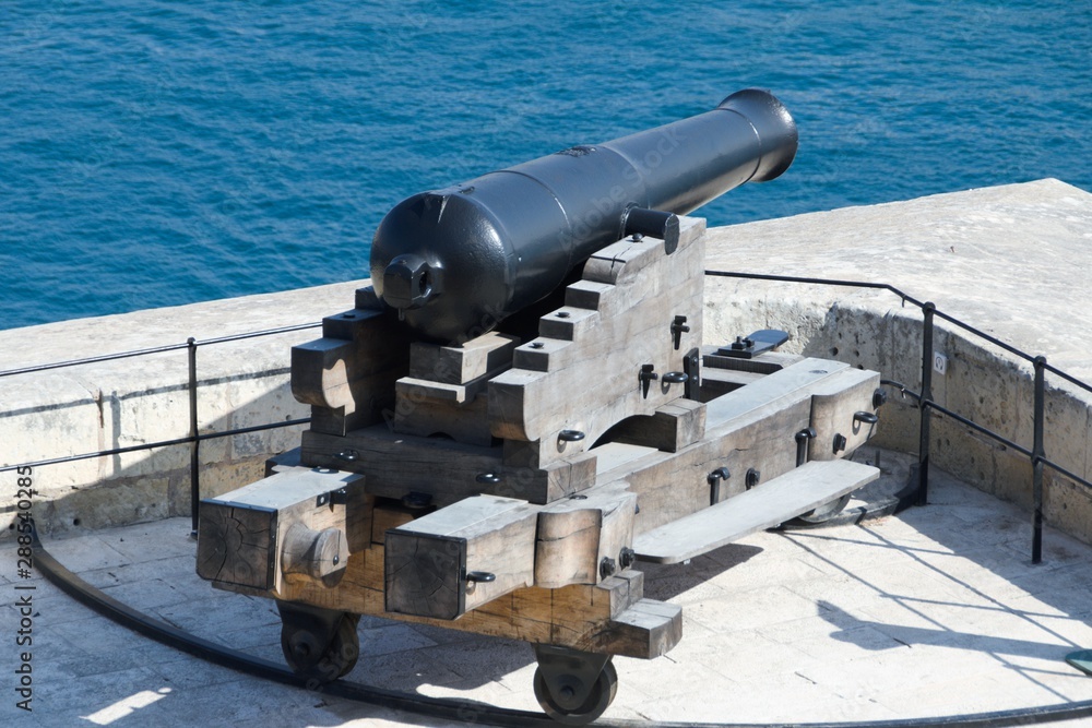 Valletta, Malta, August 2019. An old cannon on a wooden carriage guards the entrance to the harbor.