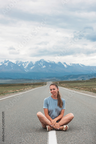 Woman sitting on the beauty road in mountain