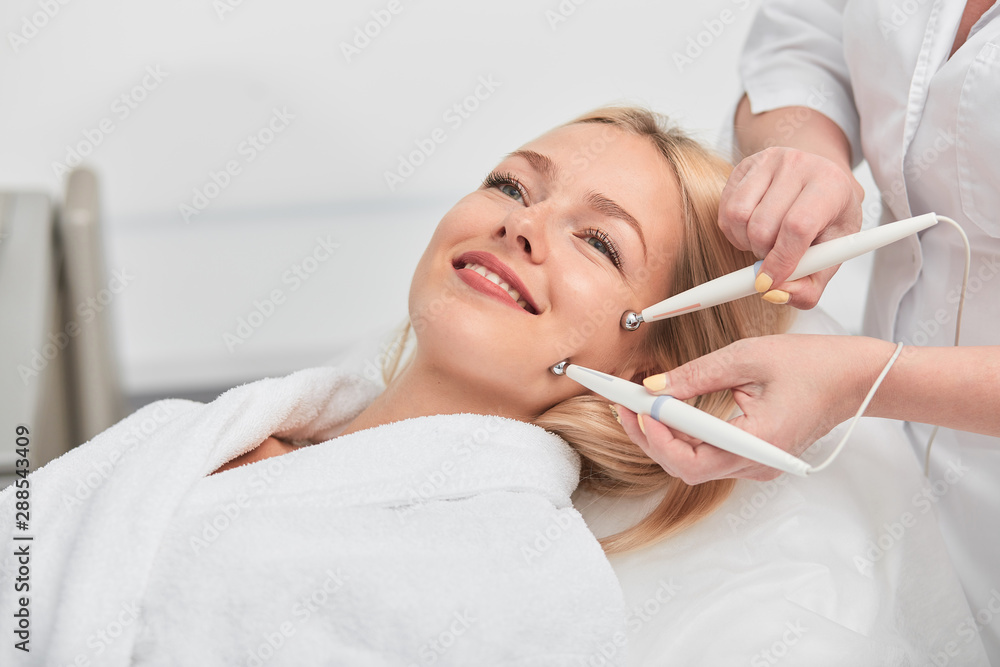 cheeful smiling awesome blonde woman having microcurrent medicine treatment. aesthetic peeling.close up photo. beauty, wellness and wellbeing cheeful smiling awesome blonde woman having microcurrent medicine treatment. aesthetic peeling.close up photo. beauty, wellness and wellbeing