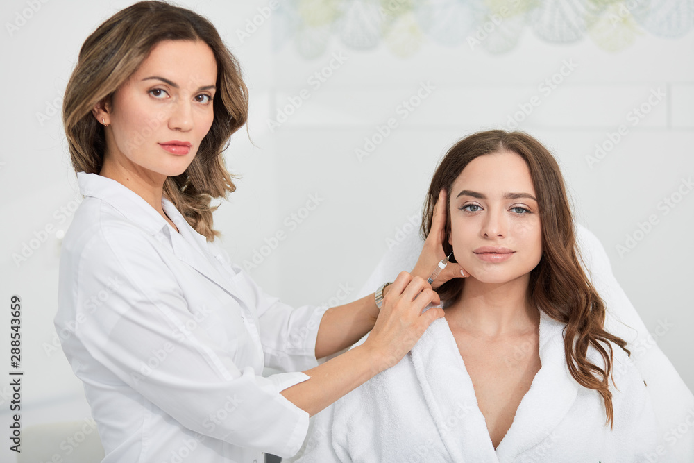 beautiful woman in white bathrobe sitting in the clinic and getting anti-aging, anti-wrinkle injection. close up portrait, lifestyle, job, profession, occupation beautiful woman in white bathrobe sitting in the clinic and getting anti-aging, anti-wrinkle injection. close up portrait, lifestyle, job, profession, occupation