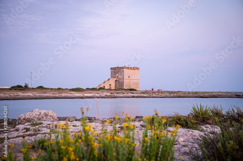 View of the ancient defensive coastal tower Torre Lapillo at the sunset. Puglia, Italy