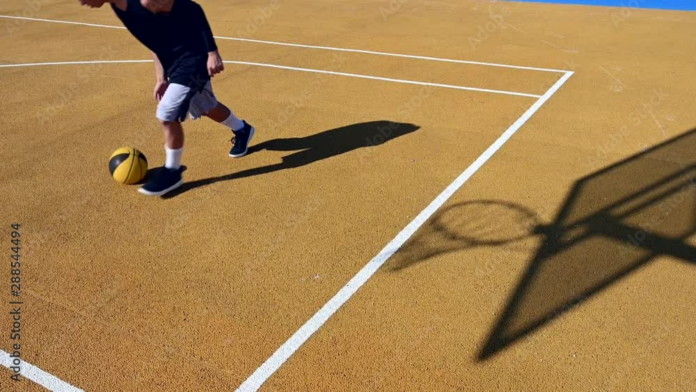 Young man playing basketball on outdoor court. Young man playing basketball on outdoor court.