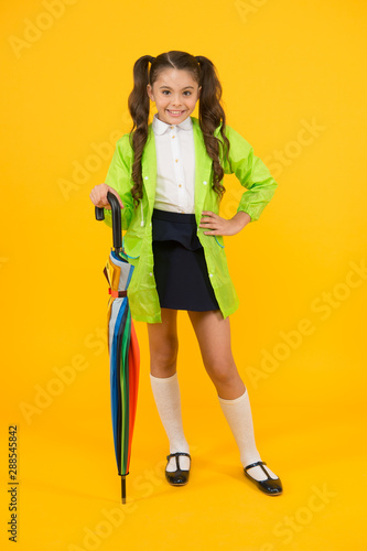 Going to school. Water resistant clothes. Protected concept. Rainproof clothes. Autumn accessory. Autumn weather. Totally ready. Schoolgirl with umbrella wear waterproof raincoat. Autumn rain