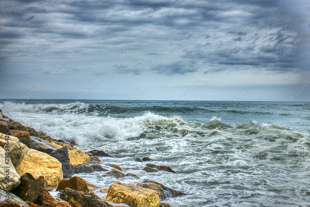 Waves crashing against the rocks by the beach Waves crashing against the rocks by the beach