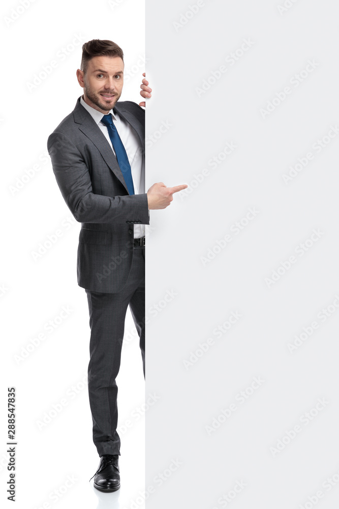 young businessman pointing finger at a big blank board young businessman pointing finger at a big blank board