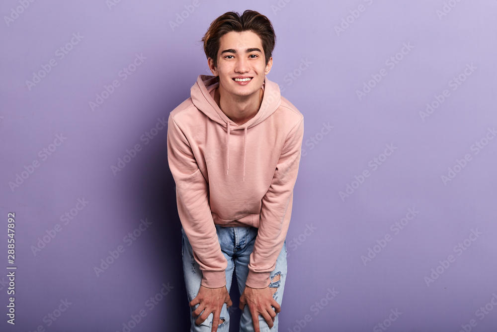Handsome young cheerful smiling man in pink fashion sweater, isolated on blue background.close up photo. people, lifestyle,copy space. Handsome young cheerful smiling man in pink fashion sweater, isolated on blue background.close up photo. people, lifestyle,copy space.