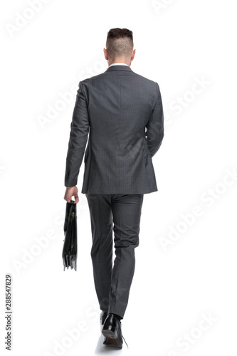 back view of a young businessman walking forward
