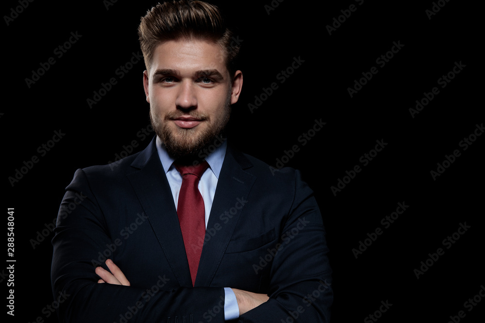 elegant businessman folding arms on black background elegant businessman folding arms on black background