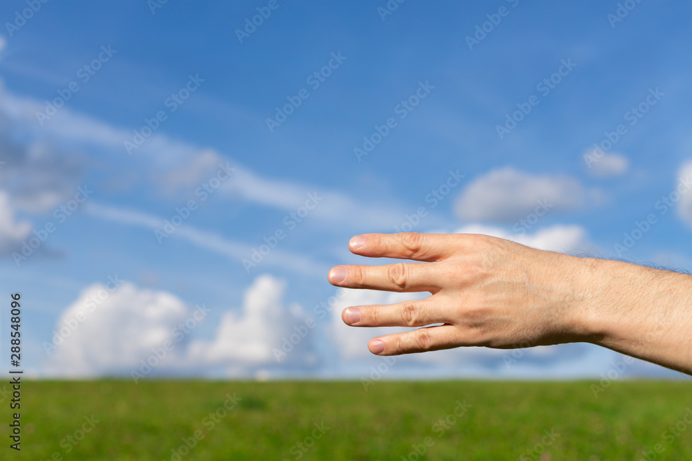 Man hand show the number four on the nature background