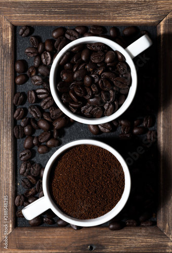 ground coffee and coffee beans in cups, top view vertical closeup