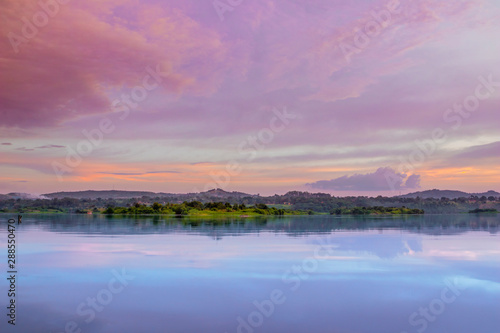 Sunset view of the Victoria Nile river, with trees growing and the reflections on the water, Jinja, Uganda, Africa photo