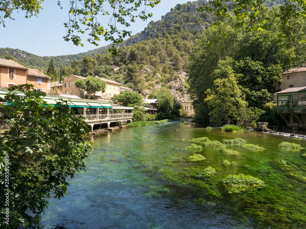 France, july 2019: Beautiful medieval village Fontaine de Vaucluse on the river shore. The poet Petrarch made it his preferred residence in the 14th century