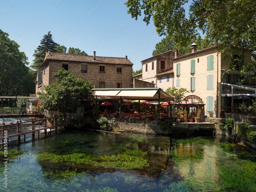 France, july 2019: Beautiful medieval village Fontaine de Vaucluse on the river shore. The poet Petrarch made it his preferred residence in the 14th century
