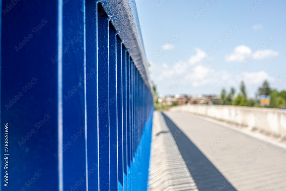 Fototapeta premium Bars of a bridge on the side of a road