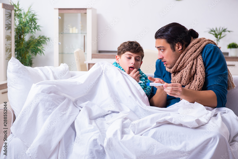 Obraz premium Young father caring for sick son