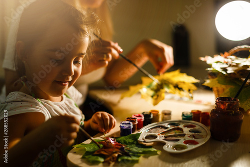 mother and daughter paint autumn leaves photo