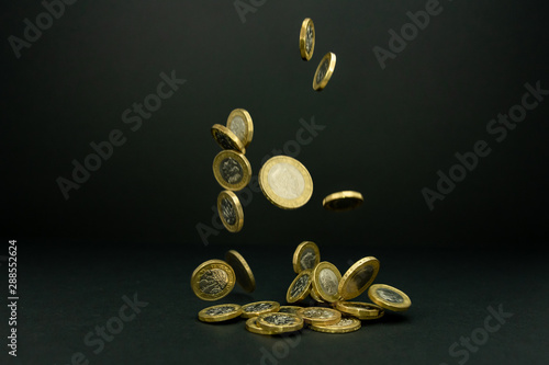 Fototapeta Falling one and two British pound coins on a black background