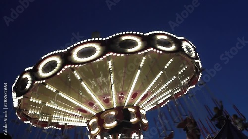 Riding on a carousel in an amusement park in the evening in a park.